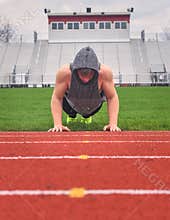 Male Teenager Doing Push Ups On Empty Football Field