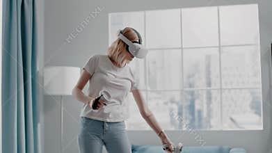 Woman waters flowers playing videogame with VR headset