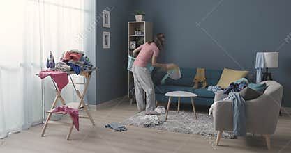 Frustrated housewife collects clothes from the ground