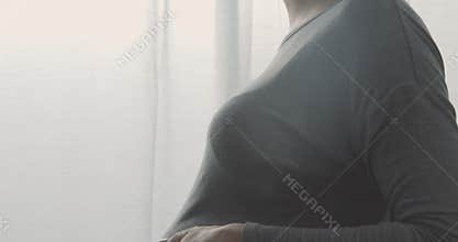 Happy pregnant woman caressing her belly