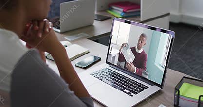 Mid section of african american woman having a video call on laptop with male colleague at office