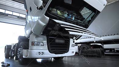 White Truck with open hood at the service station during the annual maintenance