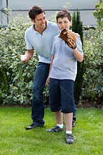 Cute little boy playing baseball with his father