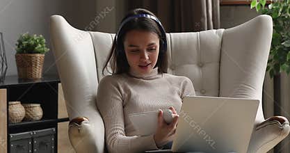 Young woman in headphones listening educational online lecture.
