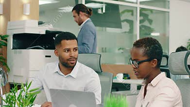 Two very good looking co- workers are in the office, having a conversation and giving each other good advice and ideas