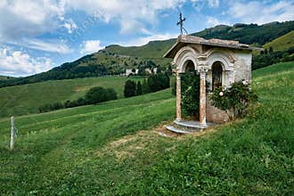 Votive capital, immersed in the Italian countryside