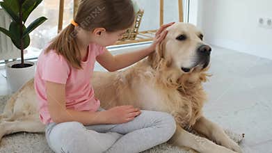 Girl petting golden retriever dog