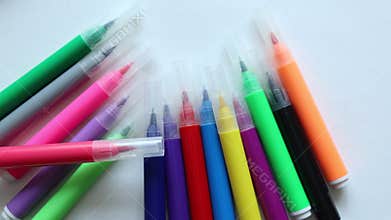 many multicolored markers moving on the white background. back to school drawing supplies concept