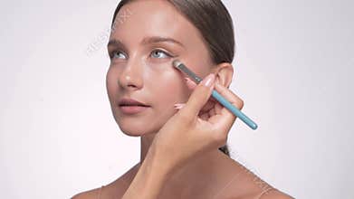 Makeup artist applies eye shadow.The concept of aesthetic cosmetology and makeup