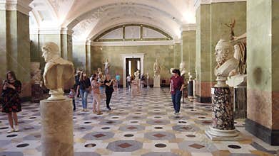 A splendid exhibition hall of the Hermitage with exhibits and groups of tourists