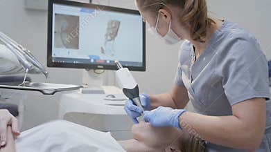 Orthodontist using 3D intraoral scanner for scanning teeth patient's. Modern dental clinic with equipment. Dentistry and