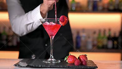 Expert barman is making cocktail at night club.