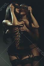 Two sexy woman kissing in darkness