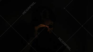 Sad girl emerging from the darkness