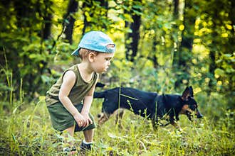 Little boy in forest with a dog, friendship