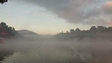 Beautiful mountain lake cover with morning dense fog over water surface serene landscape