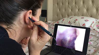 Woman using endoscope visual ear cleaner