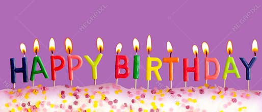 Happy birthday lit candles on purple background