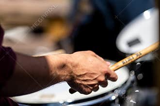 close up man and women drummer playing on a drum kit, in a band, at a gig in the sun, in Australia
