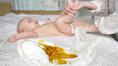 Mother hands wipe body of newborn girl after dirty diaper