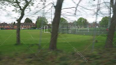 View From Train On Beautiful Scenery With Houses Buildings In City At Afternoon. Urban Scene from Window Of Car Bus And