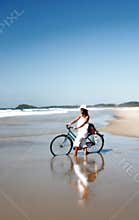 Woman with bicycle on beach