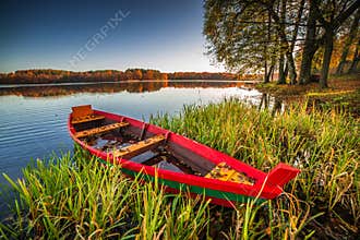 Colorful autumn landscape of boat near lake