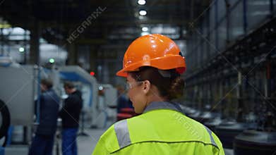 Back view mechanic walking plant. Huge industrial manufacturing modern warehouse