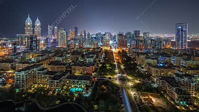 Skyscrapers in Barsha Heights district and low rise buildings in Greens district aerial night timelapse.