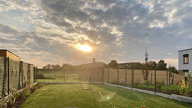 Garden during summer sunset, sprinkling water on perfect green lawn, grass, bowling green