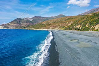 The black pebble beach of Nonza, in the Mediterranean island of Corsica. Long black beach is result of pollution from the abandone