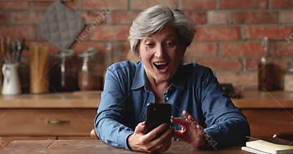 Happy older female receive great news by sms