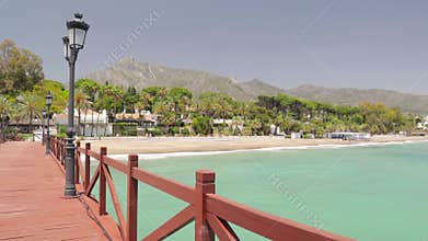 Walking on red wood bridge `Embarcadero` in Marbella.
