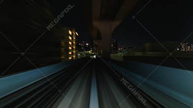 Point of view hyperlapse time-lapse of fast train travel forward on Yurikamome train line at night in Odaiba Tokyo, Japan