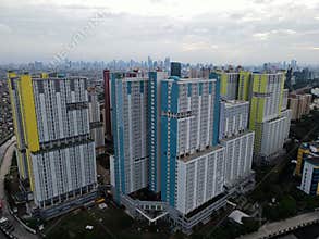 Aerial drone view of modern apartment building in Jakarta central business district with Jakarta cityscape and noise cloud.