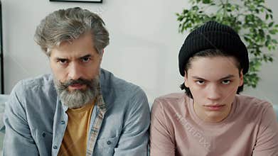 Slow motion portrait of sad and stubborn people dad and kid looking at camera at home