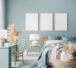 Blue Scandinavian bedroom with three vertical frames in bright design