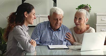 Touristic agency worker showing on laptop travel offers to couple