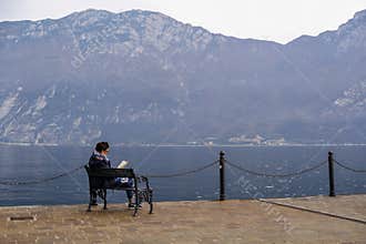 Woman reading book on the lakeshore