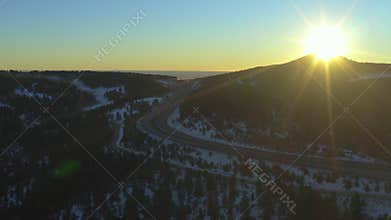 Denver highway with cars passing through mountains during winter sunrise