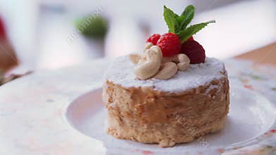 Tasty honey cake decorated with raspberry and cashew closeup