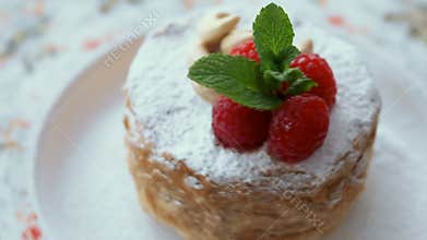 Tasty honey cake decorated with raspberry and cashew closeup