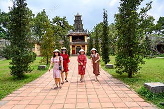 Vietnamese women strolling in garden of Thien Mu Pagoda, Hue City, Vietnam
