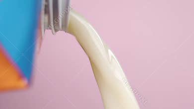 Pouring vegetable oat milk from a pack