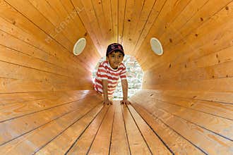 A child inside a wooden loud speaker. Casual portrait.
