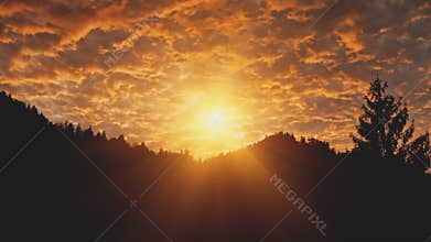 Golden sunset over mountain silhouette aerial. Sun light over mount pine forest. Dark hills and sky