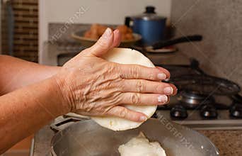 woman hands with corn dough to make colombian arepas