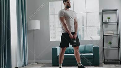 Concentrated muscular guy with beard practices squats