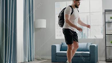 Athlete guy practices reverse lunges with weight in bag