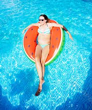 Pregnant happy woman swim on the inflatable ring
